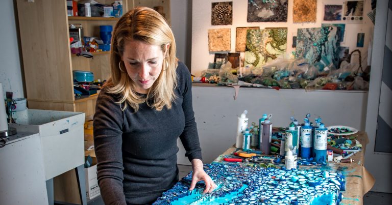 Paper artist Amy Genser works on one of her installations in her studio ...