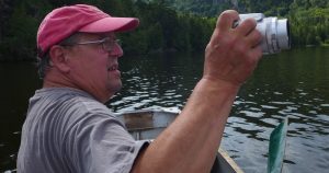 Artist Alan Bray takes a photograph from his canoe