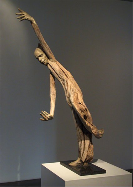 A sculpture of a human figure made from driftwood